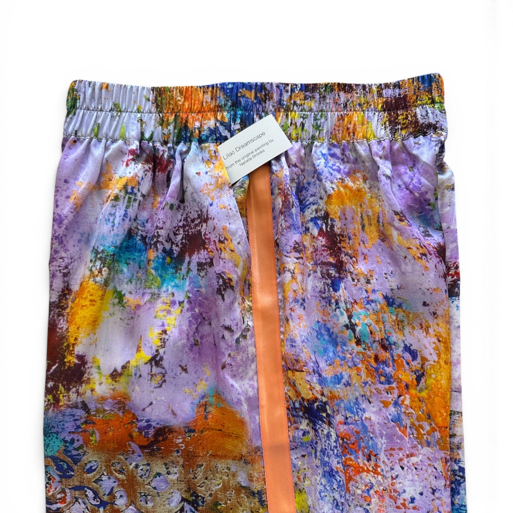 Colorful abstract patterned pants with a label on a white background