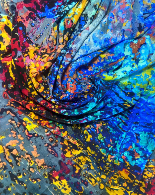 Macro detail of a silk scarf print by Art Wear by Natalia Brooks in vivid blue, yellow, and coral tones