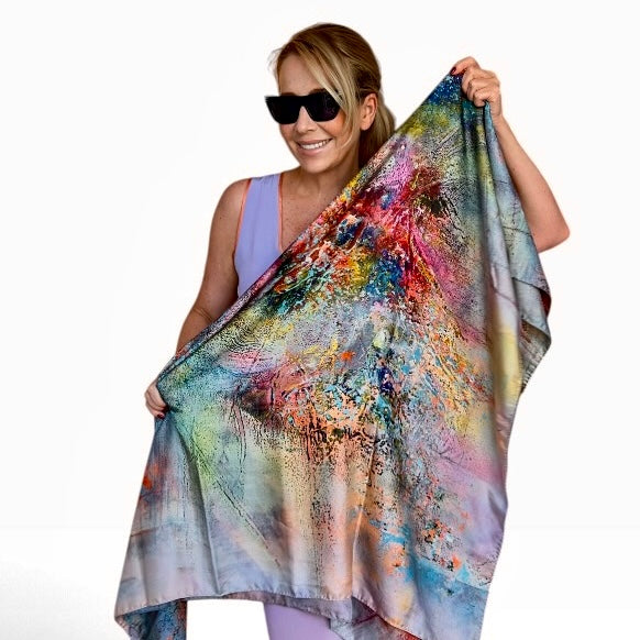 A square scarf featuring an abstract, distressed multicolor pattern with splashes of blue, orange, yellow, pink, and purple on a white background.