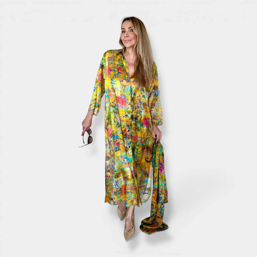 Woman wearing yellow silk kimono shirt with floral print and matching scarf on a white background