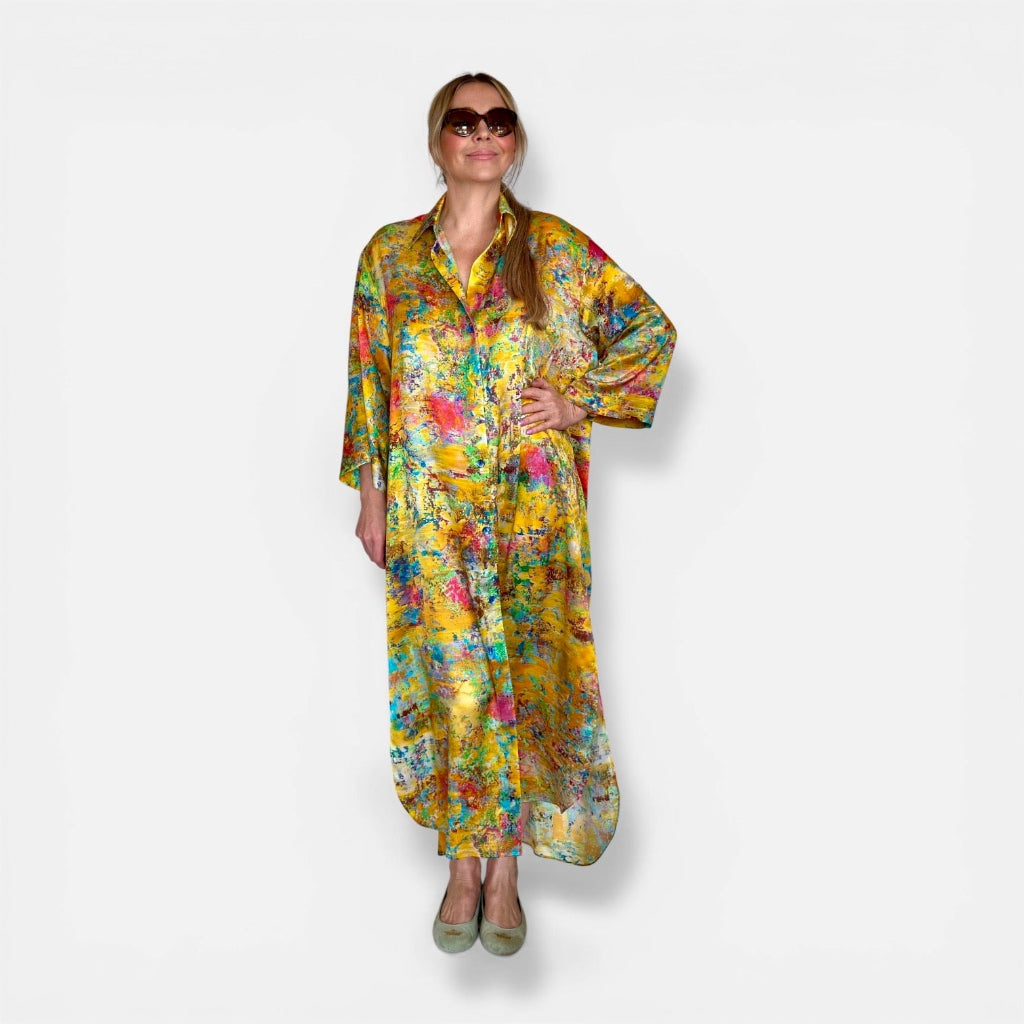 Woman wearing yellow silk kimono shirt with floral print and matching scarf on a white background