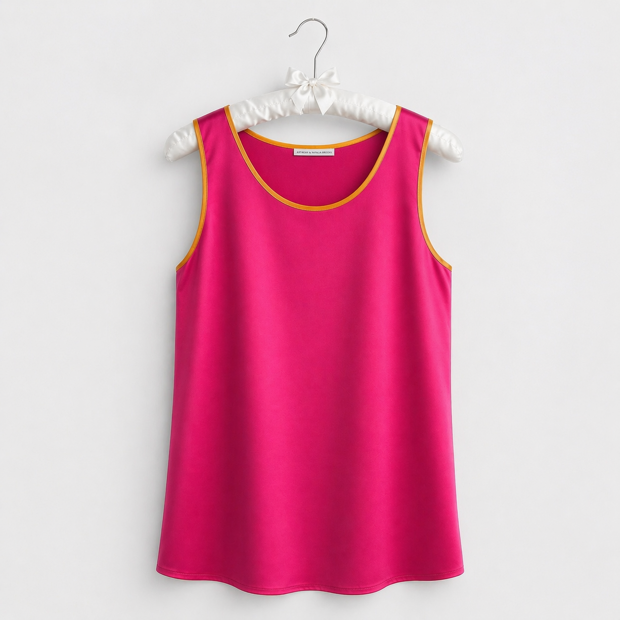 Pink sleeveless top on a hanger against a white background