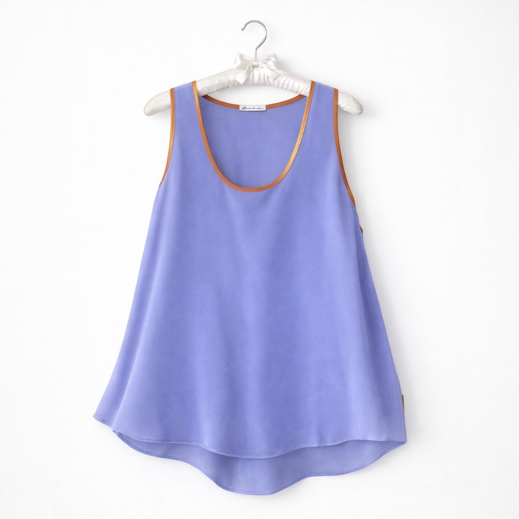 Lilac tank top with brown trim on a white hanger against a white background