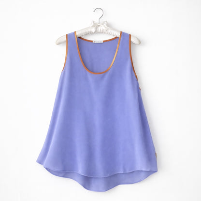 Lilac tank top with brown trim on a white hanger against a white background