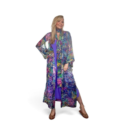 Woman wearing a colorful floral dress and jacket on a white background