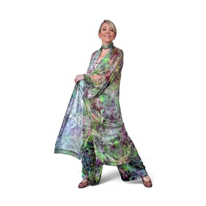 Woman wearing a colorful floral dress and scarf on a white background