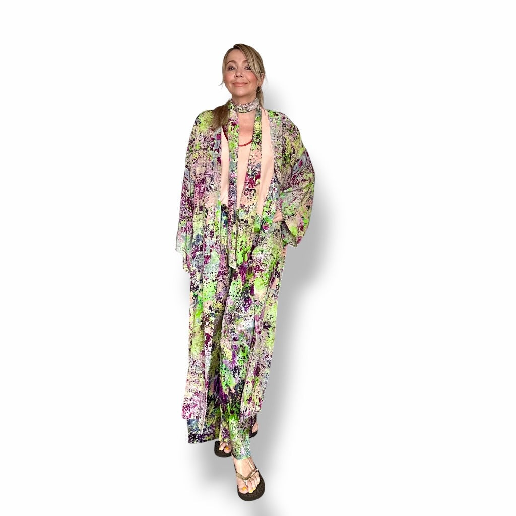 Woman wearing a floral dress with a long coat on a white background