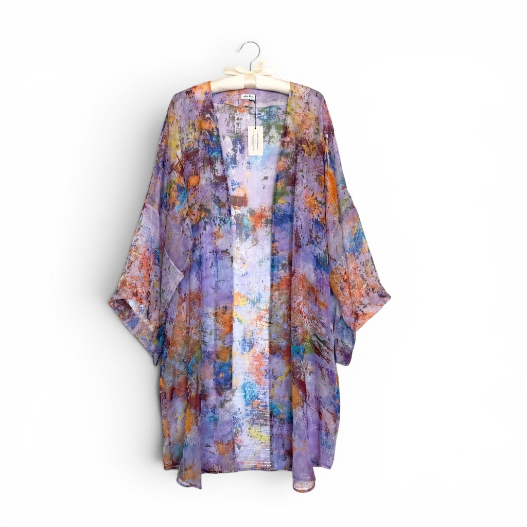 Colorful kimono-style garment on a hanger against a white background