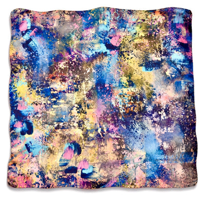 A square silk scarf featuring an abstract, colorful paint-splattered pattern with vibrant shades of blue, pink, yellow, purple, and gold.