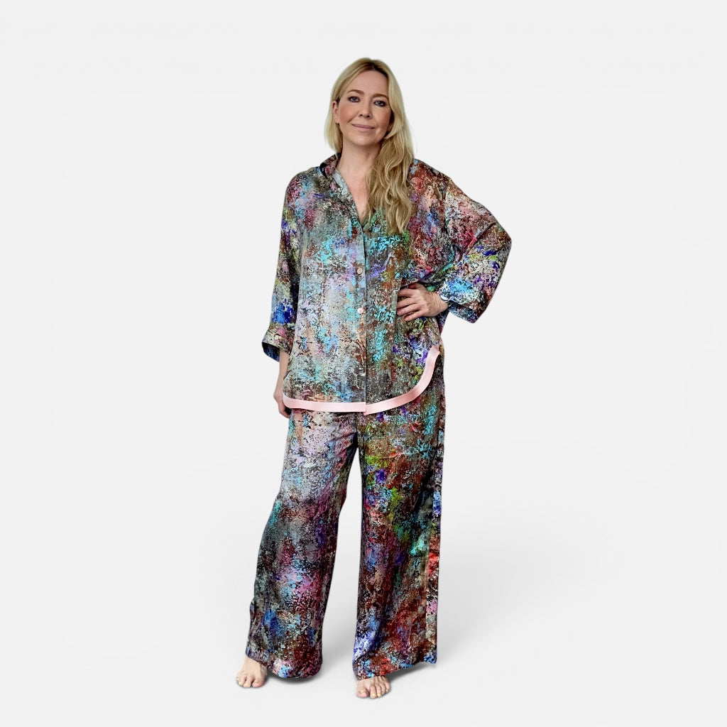Woman wearing a colorful floral pajama set on a white background