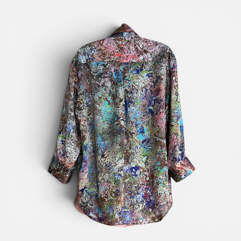 Multicolored floral patterned shirt back on a hanger with white background