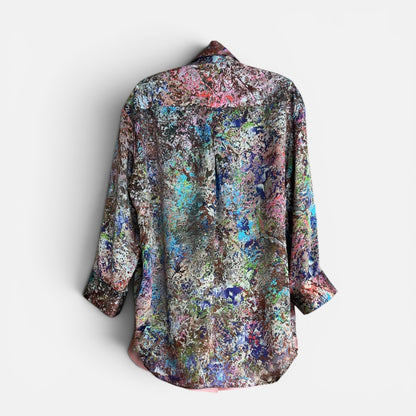 Multicolored floral patterned shirt back on a hanger with white background