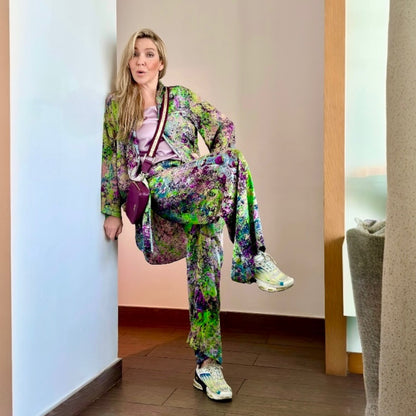 Woman in a colorful outfit standing in a doorway.