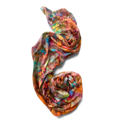 A lightweight, semi-sheer scarf with a vibrant multicolor abstract print, featuring shades of orange, pink, blue, yellow, and green, styled in a loose spiral on a white background.