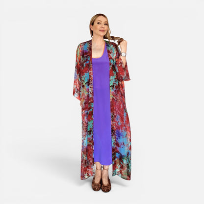 Woman wearing a colorful kimono-style jacket over a purple dress on a white background