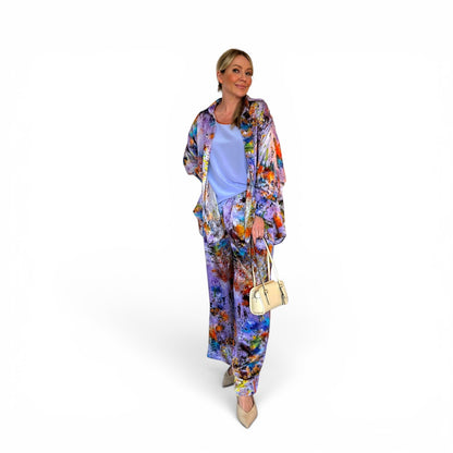 Woman wearing a colorful floral outfit with a white background