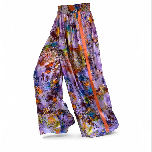 Colorful patterned pants with a prominent orange stripe on a white background